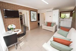 a living room with a couch and a table at Jacaranda Apartments in Swan Hill