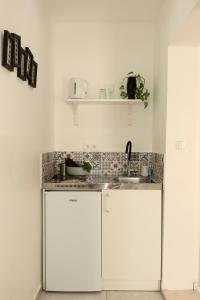 a kitchen with white cabinets and a sink at Apartmani Štambuk in Jelsa +104 photos
