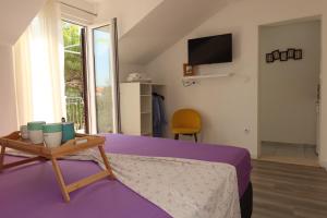 a bedroom with a bed and a table and a tv at Apartmani Štambuk in Jelsa