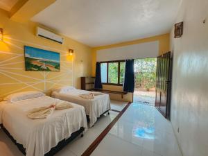 a hotel room with two beds and a window at Pousada Casa Canto das Águas in Icaraí