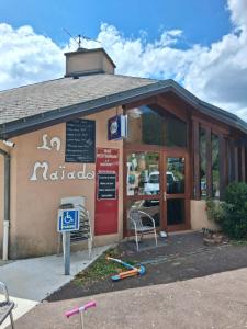 a restaurant with chairs and a sign in front of it at La maiade in Chirac-Bellevue