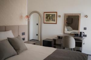 ein Schlafzimmer mit einem Bett, einem Schreibtisch und einem Spiegel in der Unterkunft Sobe Vincentius in Metković