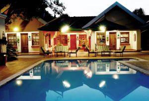 a swimming pool in front of a house at night at Waterkloof Guest House in Pretoria