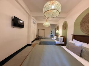 a hotel room with two beds and a television at Crown Valley Boutique Lifestyle Hotel, Ella in Ella