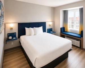 a hotel room with a large bed and a window at Microtel Inn & Suites by Wyndham Macon in Wesleyan Hills