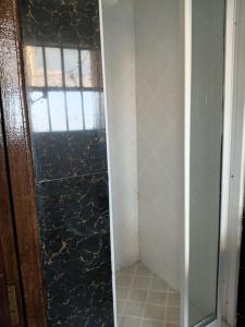a bathroom with a glass door and a window at The Sychar Palace Hotel in Kanga +16 photos