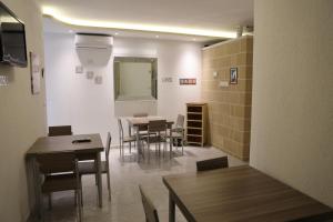a dining room with tables and chairs and a mirror at Perla Residence - Salve in Salve