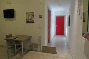 a room with a table and a red door at Perla Residence - Salve in Salve +20 photos