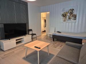 a living room with a tv and a couch and a table at Annalassa kahden makuuhuoneen asunto in Tampere