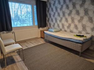 a small room with a bed and a window at Annalassa kahden makuuhuoneen asunto in Tampere