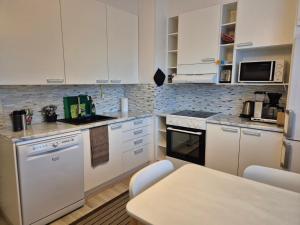 a kitchen with white appliances and a table in it at Annalassa kahden makuuhuoneen asunto in Tampere