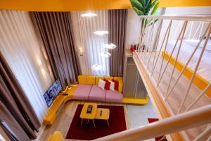 a living room with a yellow couch and a bed at Orama Suite & Spa in Korçë