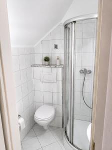 a white bathroom with a toilet and a shower at Simple studio near Kirchberg in Luxembourg