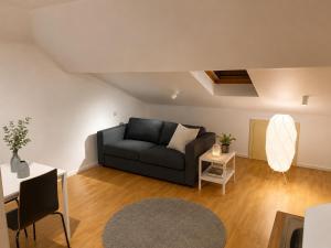 a living room with a couch and a table at Simple studio near Kirchberg in Luxembourg