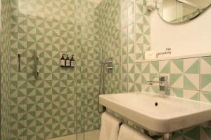 a bathroom with a sink and green and white tiles at Second Nature Southampton in Southampton +59 photos