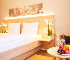 ein Schlafzimmer mit einem Bett und einer Obstschale auf einem Tisch in der Unterkunft KELKO 1A Hotel in Kehl am Rhein