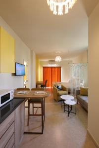 a kitchen and living room with a couch and a table at LUMI amchit in Al Qarfī