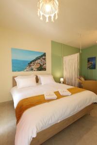 a bedroom with a large bed with a chandelier at LUMI amchit in Al Qarfī