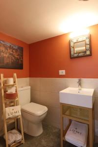 a bathroom with a toilet and a sink at LUMI amchit in Al Qarfī