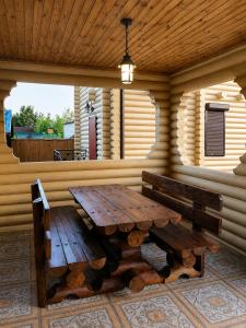 a wooden table and benches in a log cabin at Дом рыбака Маяки Ватер Сити Днестр in Mayaki +19 photos