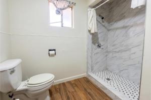a white bathroom with a toilet and a shower at Oak Motel Modesto CA in Modesto