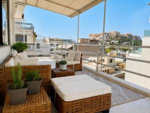 a balcony with wicker chairs and tables on a building at Syntagma Spa with Acropolis View in Athens