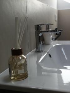 a bathroom counter with a bottle of soap and straws at Bed and Breakfast Casa Tortia in Cocconato