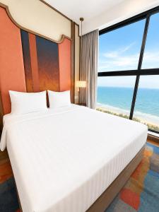 a bedroom with a bed with a view of the ocean at Thanh Son Apartment Mui Ne Beachfront in Ấp Thiẹn Ái