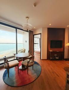 a living room with a table and chairs and a television at Thanh Son Apartment Mui Ne Beachfront in Ấp Thiẹn Ái