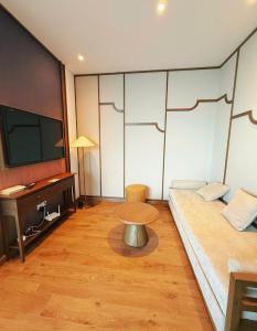 a room with a couch and a tv and a table at Thanh Son Apartment Mui Ne Beachfront in Ấp Thiẹn Ái