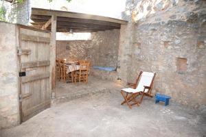 a room with a wooden door and a chair and a table at Avgonima Joy Medvial Suite in Chios