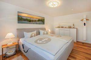 a bedroom with a large bed with a cross on the wall at Krauses Unterdeck in Loddin