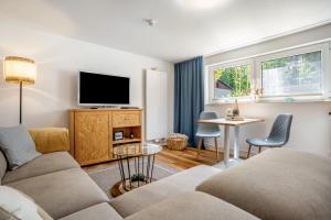 a living room with a couch and a tv at Krauses Unterdeck in Loddin