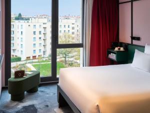 a bedroom with a bed and a large window at TRIBE Lyon Croix Rousse in Lyon