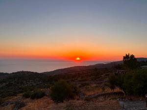a sunset with the sun setting over the ocean at Avgonima Sunset Medvial Suite in Chios +26 photos