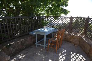 a table and two chairs sitting next to a fence at Avgonima Sunset Medvial Suite in Chios