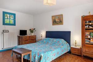 a bedroom with a bed with a blue bedspread and a table at Chambre D'hôtes Le Viel Echalier in Saint-Urbain