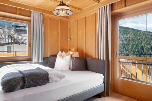 a bedroom with a bed and a large window at Schartenblick in Sarntal