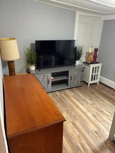 a living room with a flat screen tv on a entertainment center at Oswego 3BR Apt close to SUNY, Downtown & Lake Ontario in Oswego