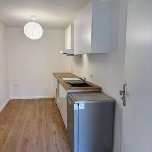 a small kitchen with white cabinets and a wooden floor at TourBase Dahlem in Dahlem