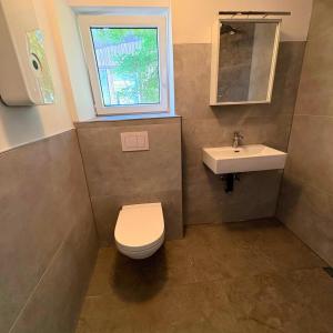 a bathroom with a toilet and a sink at TourBase Dahlem in Dahlem +2 photos