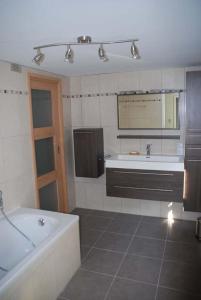 een badkamer met een bad en een wastafel bij Les Haies in Solwaster