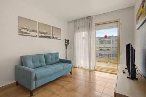 a living room with a blue couch and a television at Apartmento CT3 in Salou