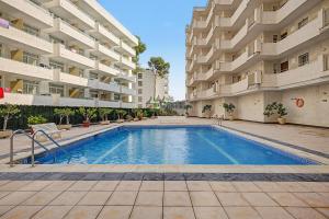 a swimming pool in front of a large building at Apartmento CT3 in Salou