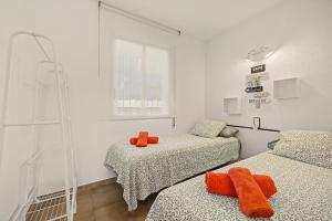 two beds in a room with orange towels on them at Apartmento CT3 in Salou +21 photos