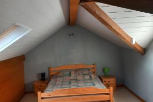 a bedroom with a wooden bed in a attic at Gîte de montagne in Ventron