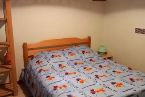 a bed with a comforter with flowers on it at Gîte de montagne in Ventron +3 photos