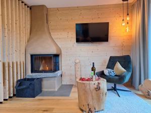 a living room with a fireplace and a chair at Schartenblick in Sarntal