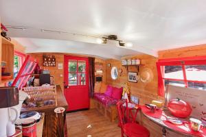 a living room with a red door and a couch at Roulotte Champêtre Bella in Brix