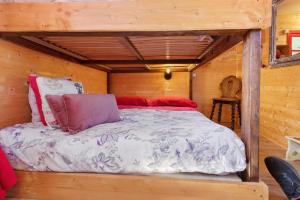 a bed in a wooden cabin with avertisementatronatronstrationstrationstrationstrationstration at Roulotte Champêtre Bella in Brix